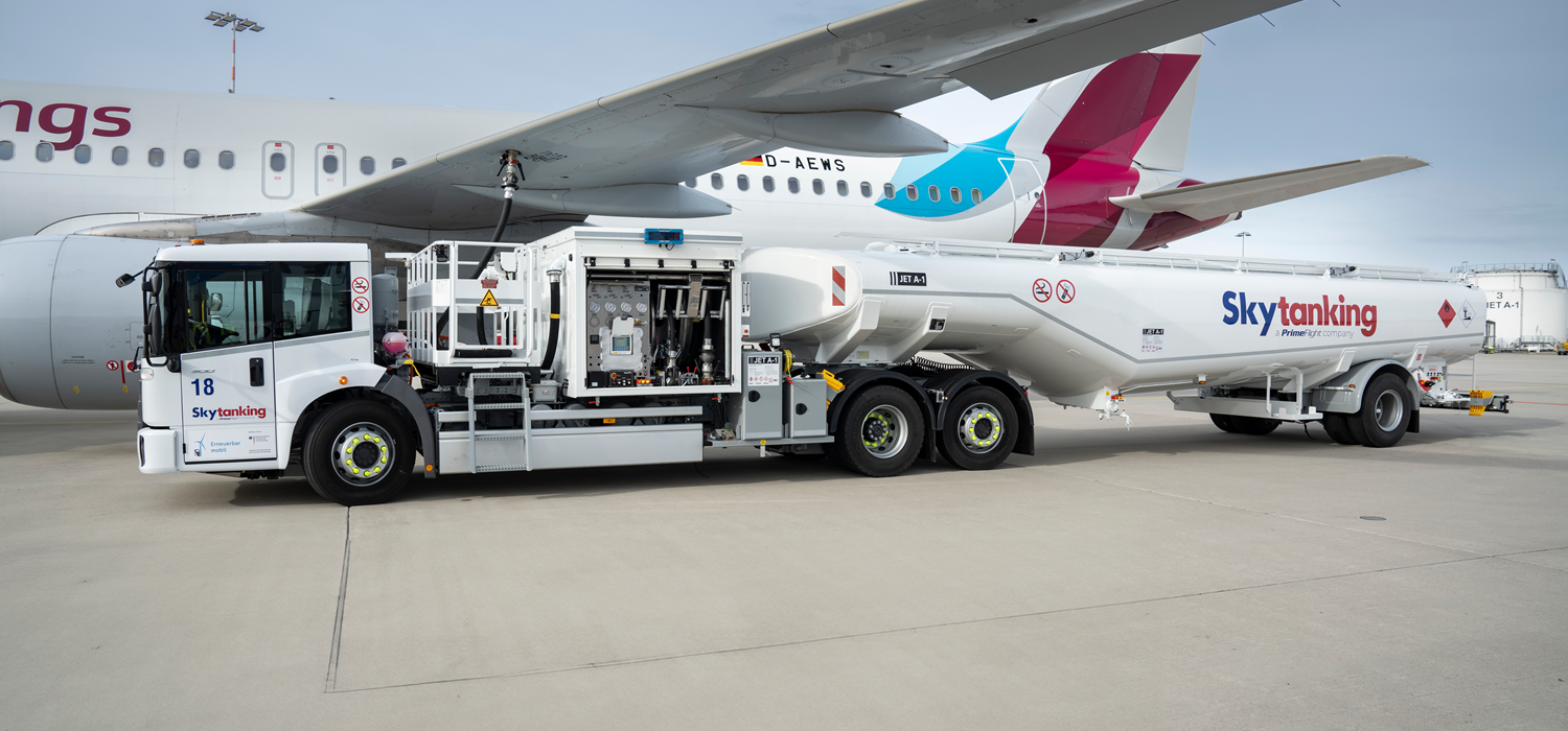 Ein elektrischer Flugzeugtankwagen der Firma Skytanking betankt ein parkendes Flugzeug.