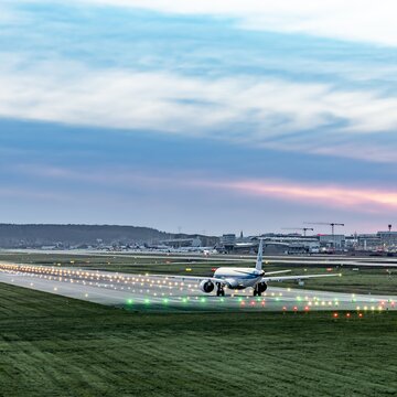Ein Flugzeug rollt auf der beleuchteten Startbahn.
