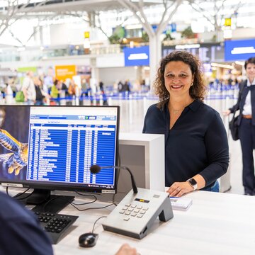 Flughafenmitarbeiter gibt Reisenden am Flughafen Stuttgart Auskunft.