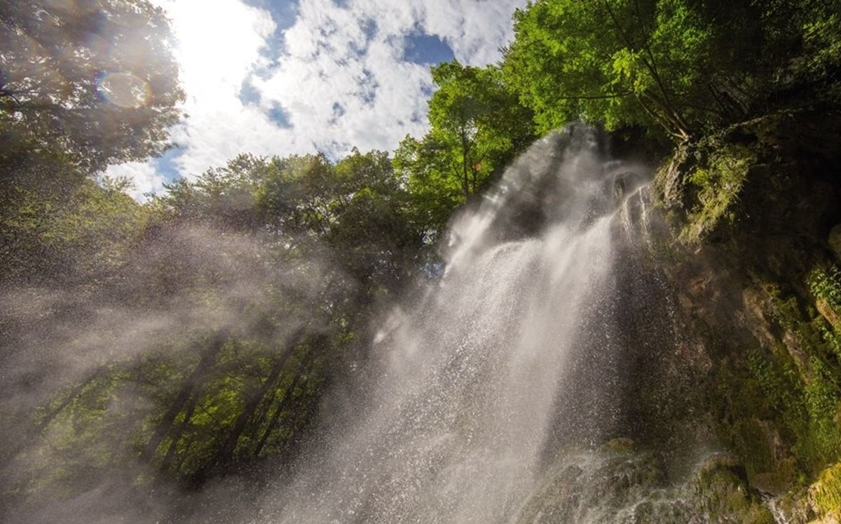 Blick von unten auf Wasserfall im Wald